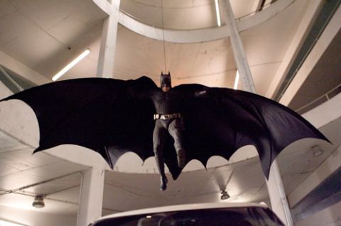 1988 Mercury Grand Marquis - A person dressed as Batman is suspended in the air with a large black cape spread out.