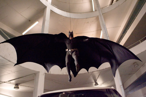 Batman in mid-air with his cape spread out.