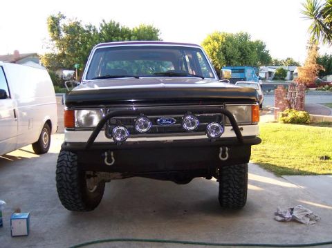 1991 Ford Bronco - Front view of a two-tone Ford Bronco with an aftermarket bumper and fog lights.