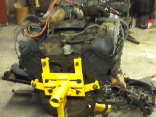 1979 Ford Bronco - An engine is mounted on a yellow stand, likely for repair or rebuilding.