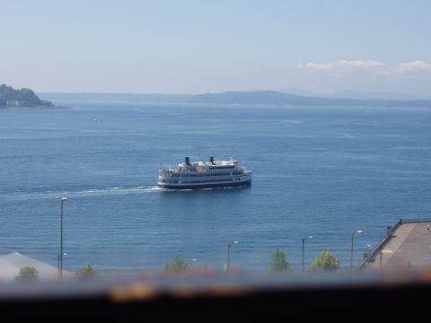 1992 Ford Taurus - A ferry boat travels across a body of water, with land visible in the distance under a clear sky.