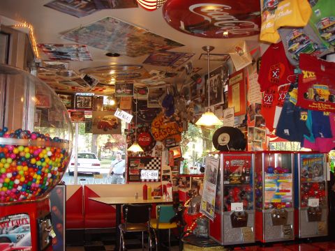 1992 Ford Taurus - A diner interior is decorated with vintage signs, posters, and merchandise, including a large gumball machine.