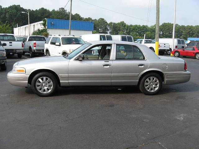 Side view of a silver Ford Crown Victoria sedan in a parking lot