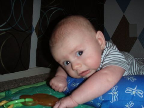 1997 Ford F-250 - A baby is on a playmat with a toy nearby. The background has a patterned curtain.