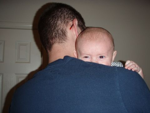 1997 Ford F-250 - A baby looks over a person's shoulder, with a door visible behind them.