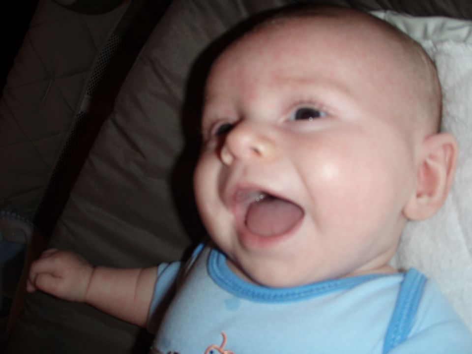 Close-up of a baby's face with mouth open and blue onesie