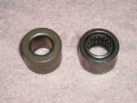 1994 Ford Bronco - Two roller bearings are shown side-by-side on a textured pink surface.
