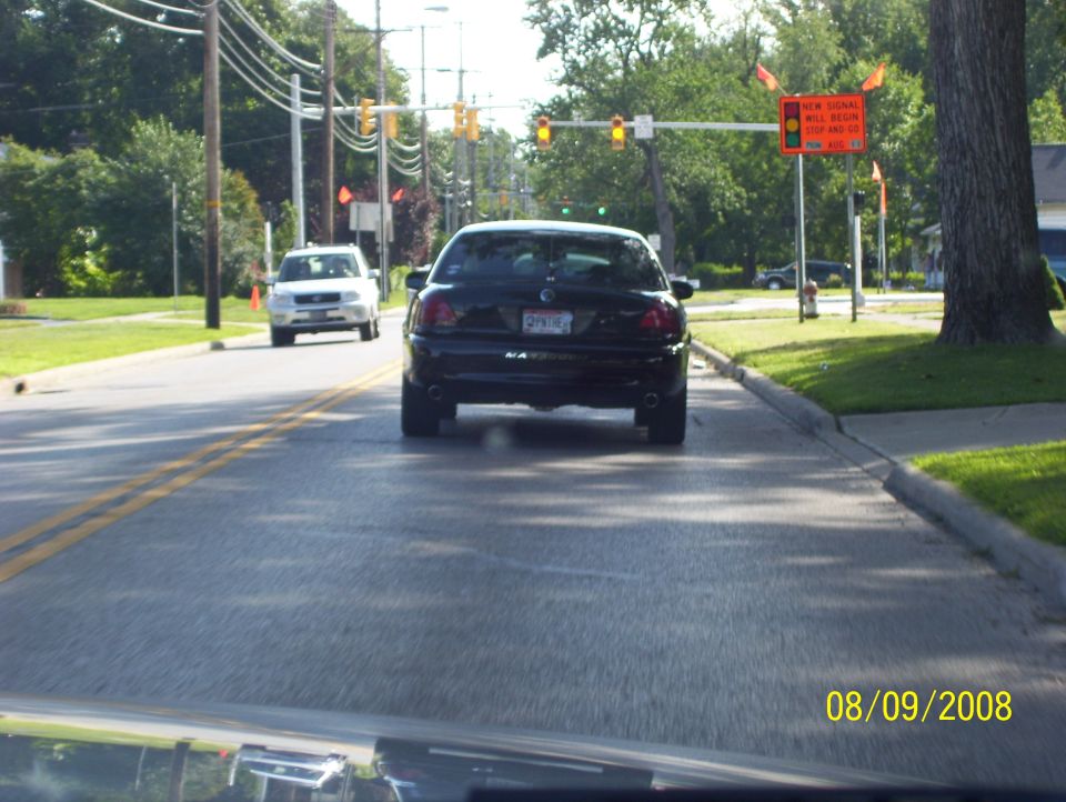 Black sedan from rear, license plate visible