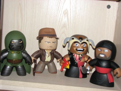 1991 Ford Bronco - A collection of four stylized figures, including characters resembling Doctor Doom and Indiana Jones, are displayed on a shelf.
