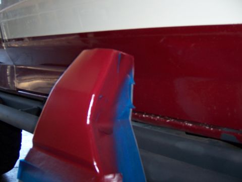 1991 Ford Bronco - Close-up of a vehicle's side panel, showing a red fender flare with blue tape.