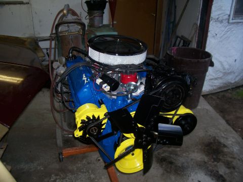 1970 Ford Ranchero - A blue engine with yellow accessories and a black fan is displayed on a stand.