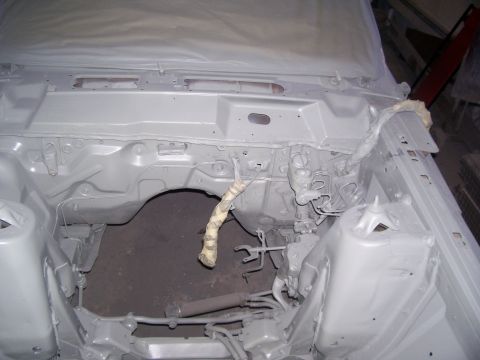 1970 Ford Ranchero - The engine bay of a vehicle is shown covered in primer, indicating it is in the process of being restored.