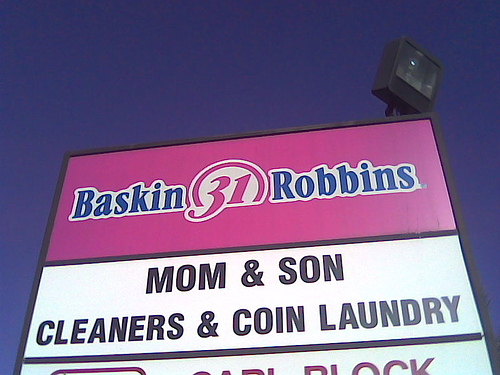 Sign with Baskin Robbins logo and text for Mom & Son Cleaners & Coin Laundry