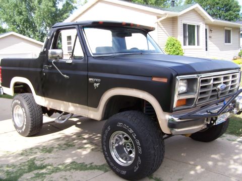 1986 Ford Bronco - This lifted Ford Bronco features a two-tone paint scheme and off-road tires.