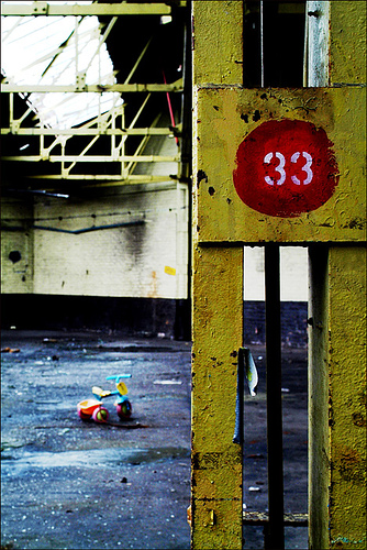 1992 Ford Bronco - An abandoned industrial scene with a toy tricycle and a yellow post marked with the number 33.