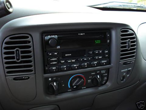2007 Ford Mustang - The dashboard of a car features a radio, climate controls, and air vents.