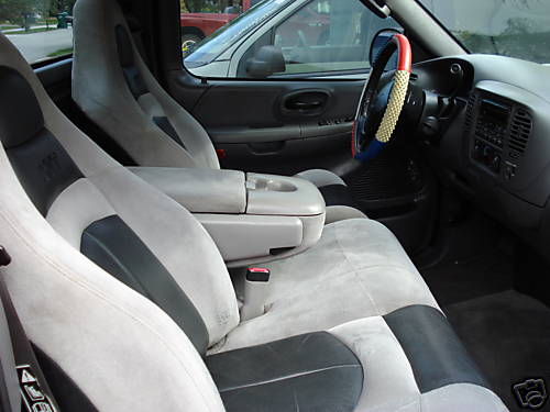 Interior view of a truck with two-tone cloth seats and a custom steering wheel cover