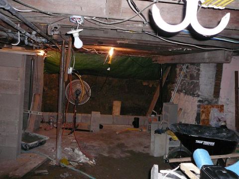 1997 Mercury Grand Marquis - An unfinished basement scene shows construction materials, electrical wiring, and a fan.