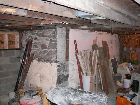 1997 Mercury Grand Marquis - Basement interior shows exposed beams, stone foundation, and stored building materials.