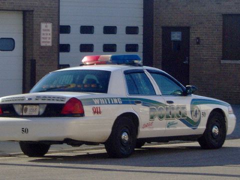 1992 Ford Bronco - A Whiting police car is parked in front of a building with garage doors.