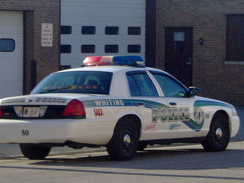Whiting police car with "POLICE" and "911" markings, side view