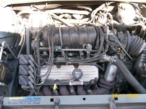 1995 Mercury Grand Marquis - The engine bay shows a V6 engine with various components like spark plug wires and an intake manifold.