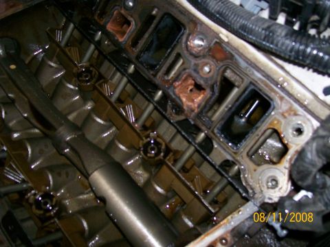 1995 Mercury Grand Marquis - Close-up of an engine's intake manifold showing signs of wear and tear, with a tool positioned nearby.