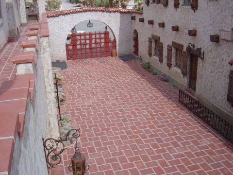 2001 Ford Mustang - A courtyard with a red gate and a building Spanish architectural elements.