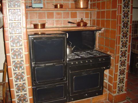 2001 Ford Mustang - An antique stove with a kettle on its burners, surrounded by decorative tilework.
