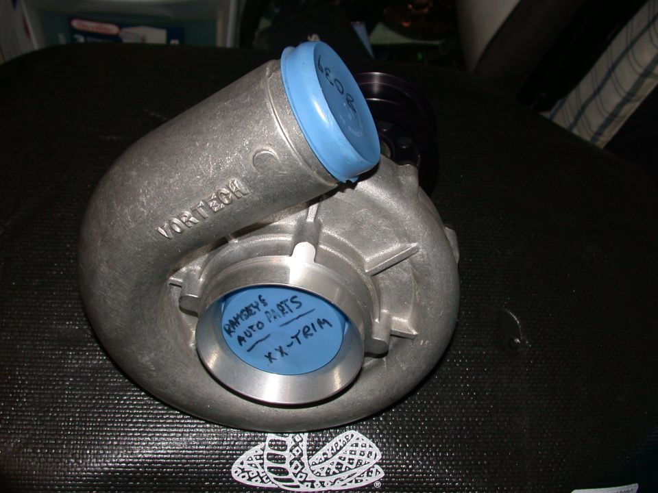 Vortech centrifugal supercharger with blue protective caps on black mat