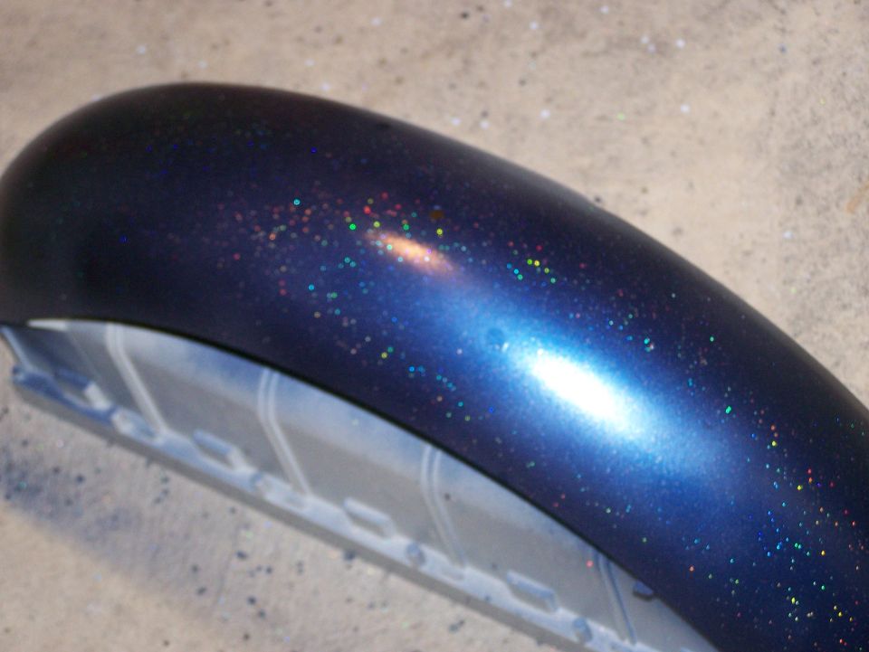 Blue metalflake painted motorcycle fender on a concrete floor