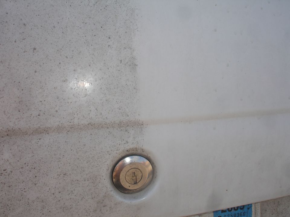 Close-up of a dirty and clean surface split, with a chrome fuel door.