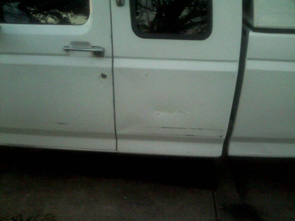 White pickup truck passenger door with a dent and scratch.