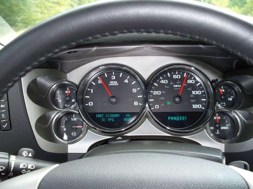 Vehicle dashboard with steering wheel, tachometer, speedometer, and gauges.