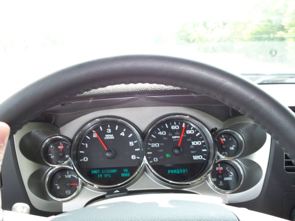 Vehicle dashboard with steering wheel, speedometer, and tachometer.