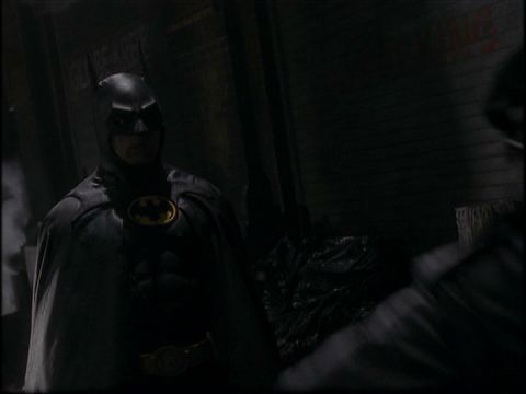 1988 Mercury Grand Marquis - A dark, grainy image shows a person dressed as Batman standing in what appears to be an alleyway.