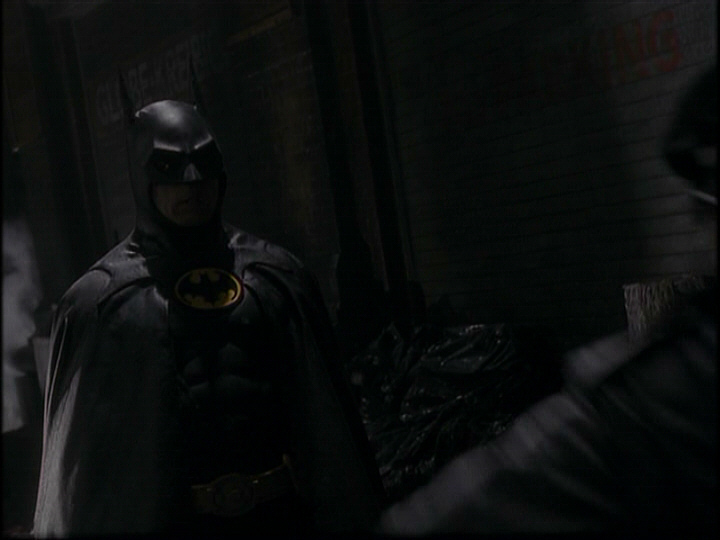Person dressed as Batman in an alleyway
