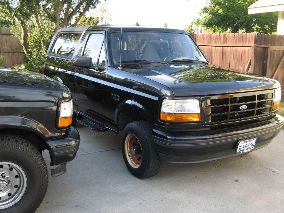 Black 1980s Ford Bronco parked in a driveway.