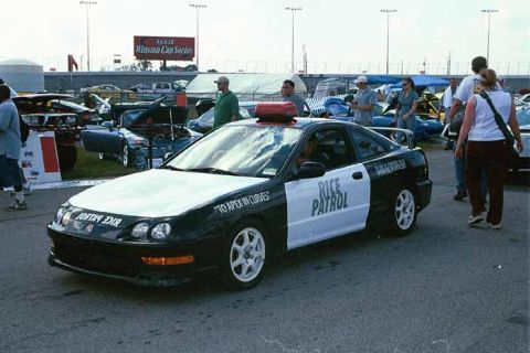 2002 Nissan Altima - A modified Honda coupe with a police-themed livery is parked at an outdoor event.