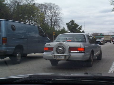2002 Nissan Altima - A silver sedan with an external spare tire is seen on the road.