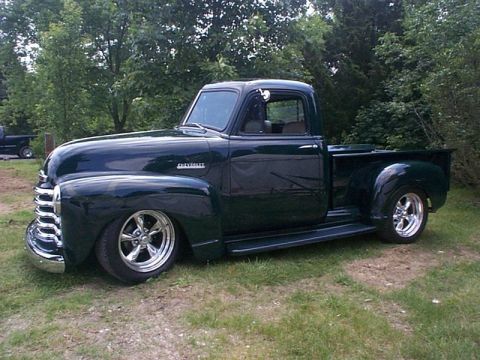2007 Ford Mustang - Photograph of a completed dark green Chevrolet pickup on grass, not a technical document.