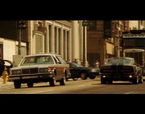 1988 Mercury Grand Marquis - A 1988 Mercury Grand Marquis station wagon with wood paneling is parked on a city street next to a dark green sedan. A classic muscle car w…