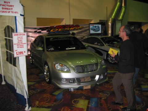 2002 Nissan Altima - A silver 2002 Nissan Altima is displayed with a custom grille and body kit, alongside another vehicle.