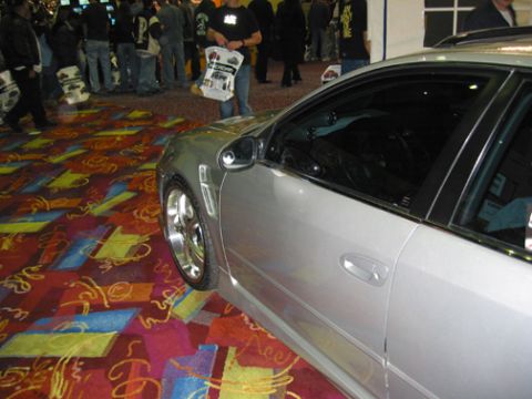 2002 Nissan Altima - A silver sedan is parked indoors on a colorful carpeted floor.
