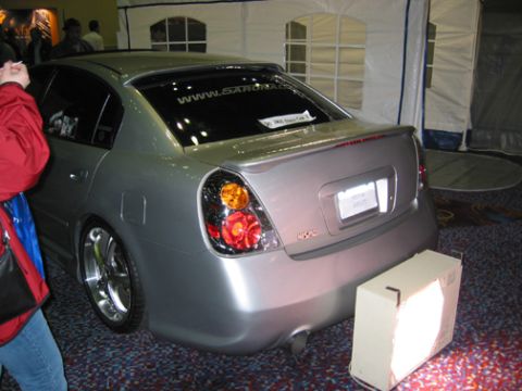 2002 Nissan Altima - A silver sedan is parked indoors, with a sticker on its rear window and custom taillights.
