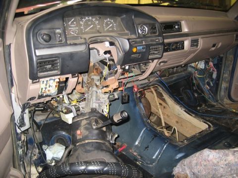 1995 Ford Bronco - Interior view of a 1995 Ford Bronco with the dashboard disassembled, revealing exposed wiring and the steering column.