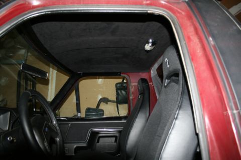 1989 Ford Bronco - The interior of a vehicle is shown, racing seats and a roll cage, with a watermark from SuperMotors.net.