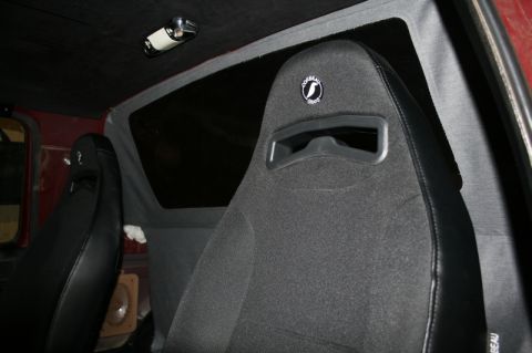 1989 Ford Bronco - The interior features aftermarket bucket seats with a distinctive logo on the headrest, visible through the side window.