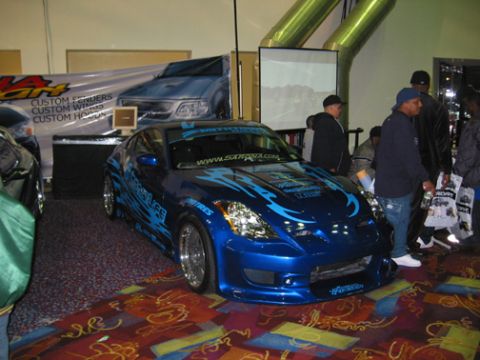 2002 Nissan Altima - A custom blue sports car with flame graphics is displayed indoors.