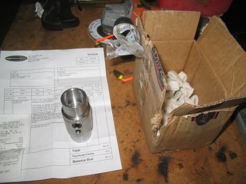 1989 Ford Bronco - A metal part and an invoice are on a workbench next to a shipping box.